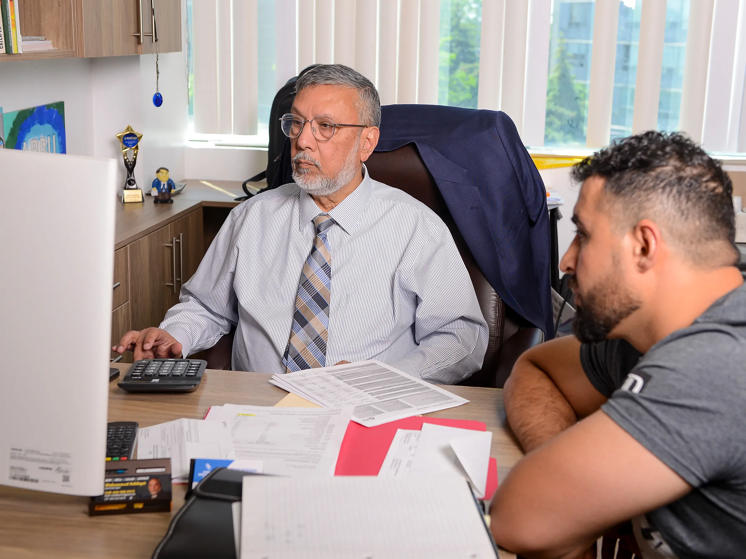 Irfan reviewing a return with a client at the Hawks office